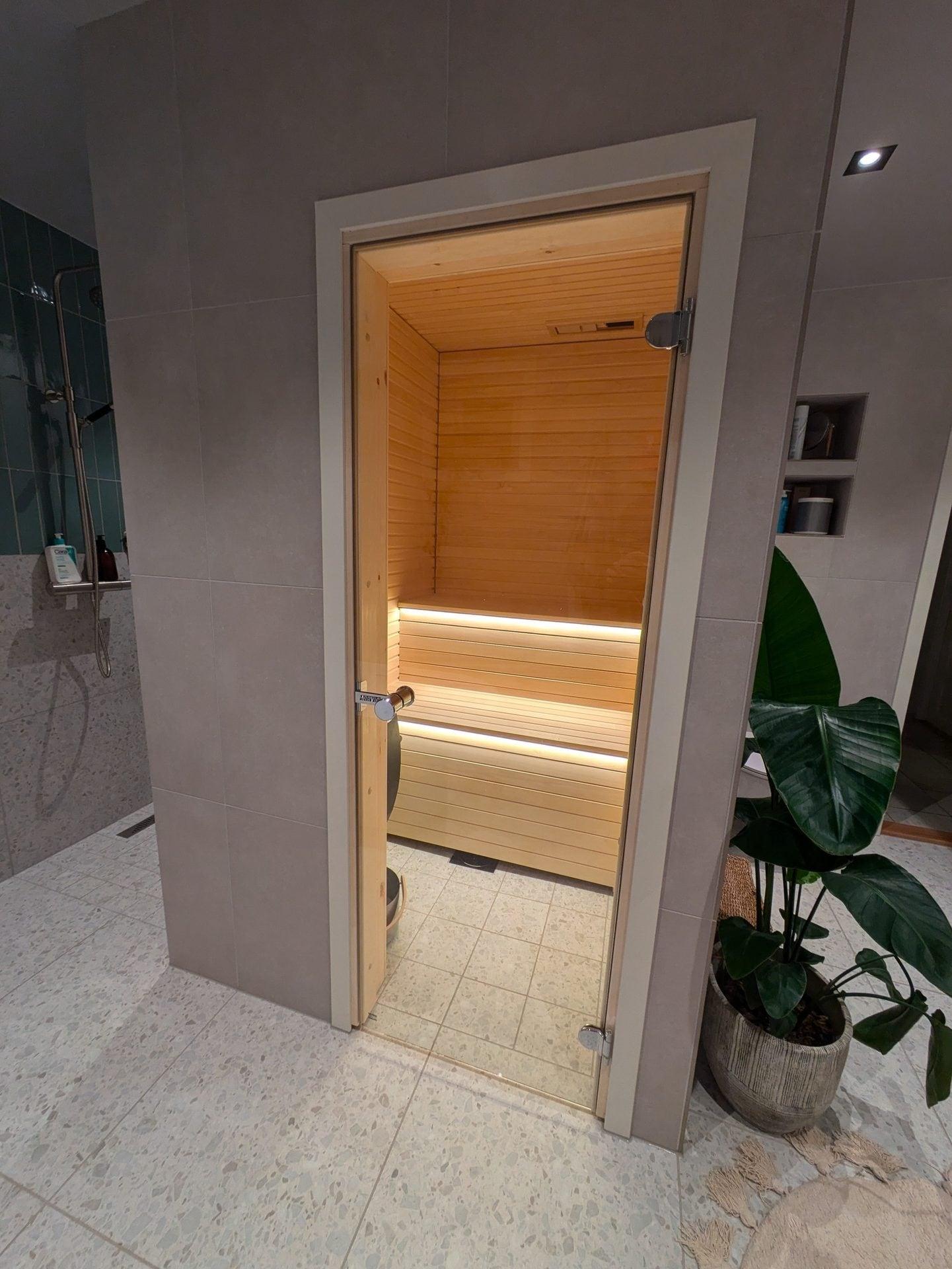 Bad med glassdør inn til en badstue