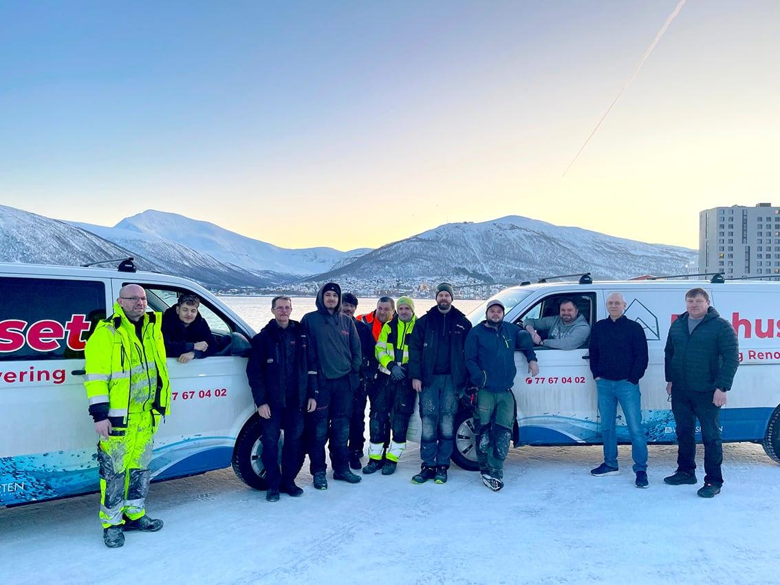 Gjengen i Flishuset foran firmabilene, i snøen